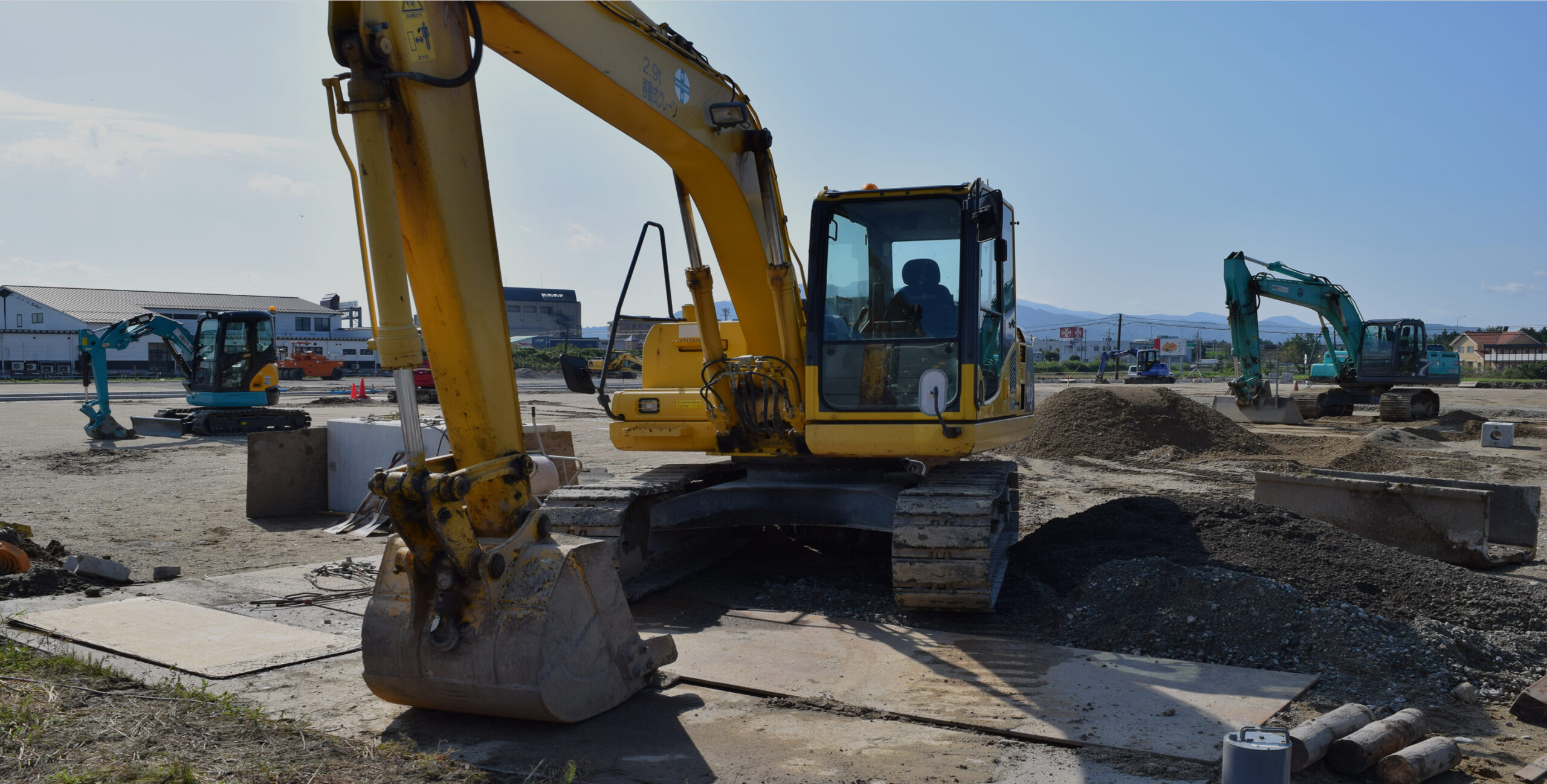 地盤改良工事の現場で稼働するバックホーや重機
