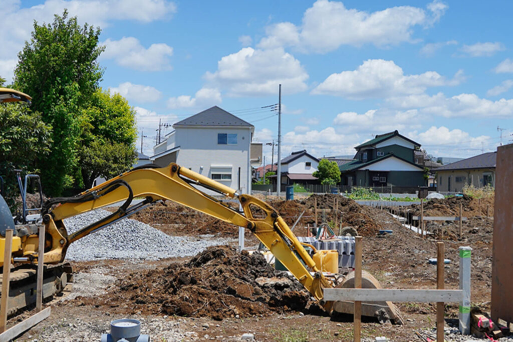 住宅街の建設現場で稼働するショベルカー