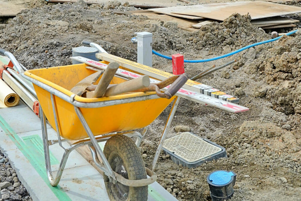 建設現場で使われる黄色い一輪車と工具